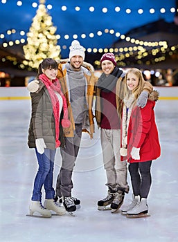 Happy friends at christmas skating rink