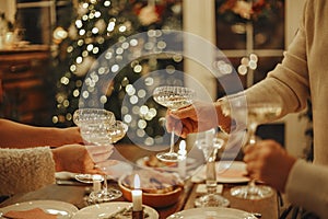 Happy friends clinking champagne glasses while celebrating New Years Eve or Christmas