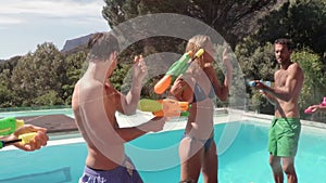 Happy friends doing water gun battle