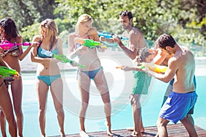 Happy friends doing water gun battle