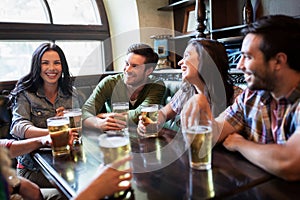 Happy friends drinking beer at bar or pub