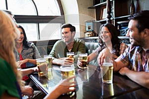 Happy friends drinking beer at bar or pub