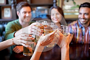 Happy friends drinking beer at bar or pub