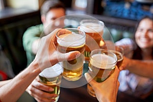 Happy friends drinking beer at bar or pub