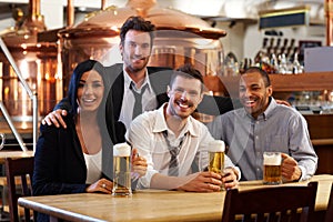 Happy friends drinking beer at pub