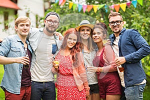 Happy friends with drinks at summer garden party