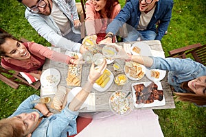 Happy friends with drinks at summer garden party