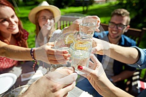 Happy friends with drinks at summer garden party