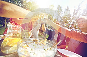 Happy friends with drinks at summer garden party