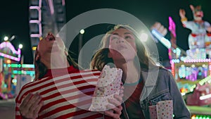 Happy friends eating popcorn walking funfair closeup. Joyful funny girls throw