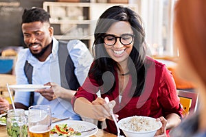 Happy friends eating at restaurant