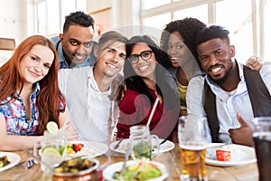 Happy friends eating at restaurant