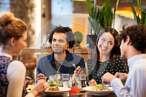 Happy friends eating at restaurant