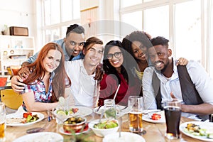 Happy friends eating at restaurant