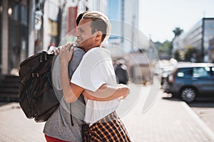 Happy friends embracing during meeting at street