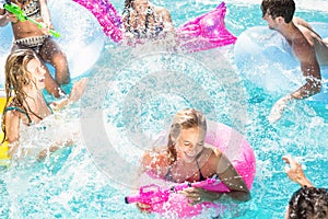 Happy friends enjoying in the swimming pool