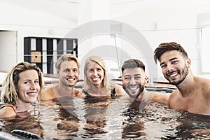 Happy friends enjoying vacations in jacuzzi luxury house - Young people having fun together in hot tub