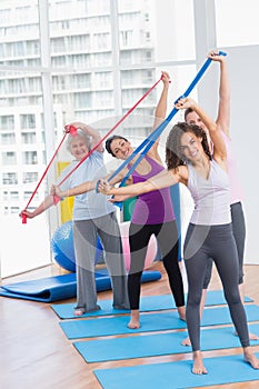 Happy friends exercising with resistance bands