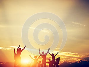 Happy friends, family jumping together at sunset.