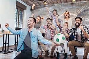 Happy friends or football fans watching soccer on tv