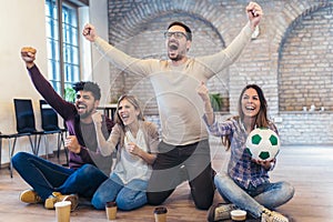 Happy friends or football fans watching soccer on tv