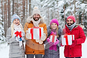 Happy friends with gift boxes in winter forest