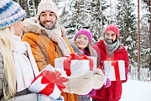 Happy friends with gift boxes in winter forest