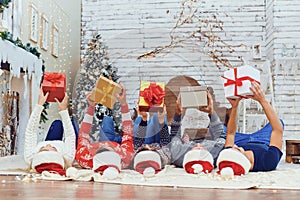 Happy friends with gifts lying on the floor in Christmas.