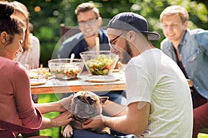 Happy friends having dinner at summer garden party