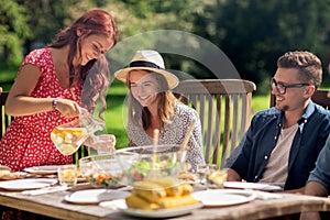 Happy friends having dinner at summer garden party