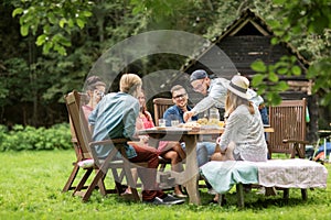 Happy friends having dinner at summer garden party