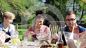 Happy friends having dinner at summer garden party