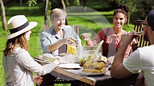 Happy friends having dinner at summer garden party