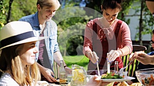 Happy friends having dinner at summer garden party