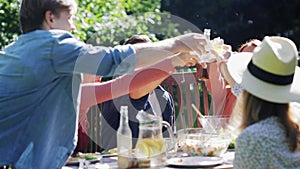 Happy friends having dinner at summer garden party