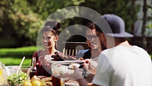 Happy friends having dinner at summer garden party