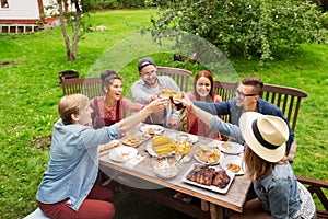 Happy friends having dinner at summer garden party