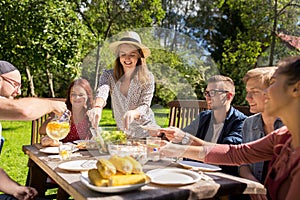 Happy friends having dinner at summer garden party