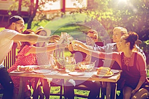 Happy friends having dinner at summer garden party