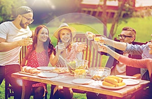 Happy friends having dinner at summer garden party