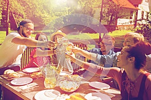 Happy friends having dinner at summer garden party