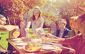 Happy friends having dinner at summer garden party