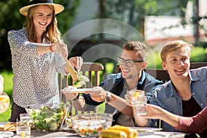 Happy friends having dinner at summer garden party