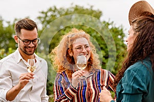 Happy friends having fun drinking wine at vineyard