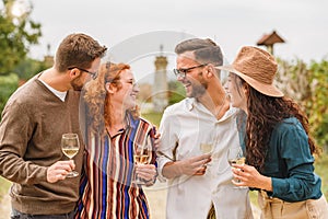 Happy friends having fun drinking wine at vineyard