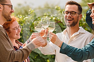 Happy friends having fun drinking wine at vineyard