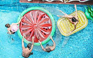 Happy friends having fun inside swimming pool during summer vacation - Focus on heads