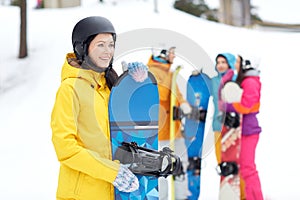 Happy friends in helmets with snowboards