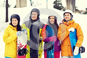 Happy friends in helmets with snowboards