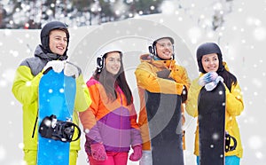 Happy friends in helmets with snowboards